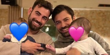 O Αντρέας Γεωργίου και ο Νίκος Πολυδερόπουλος ποζάρουν μαζί, κρατώντας τα μωρά τους αγκαλιά